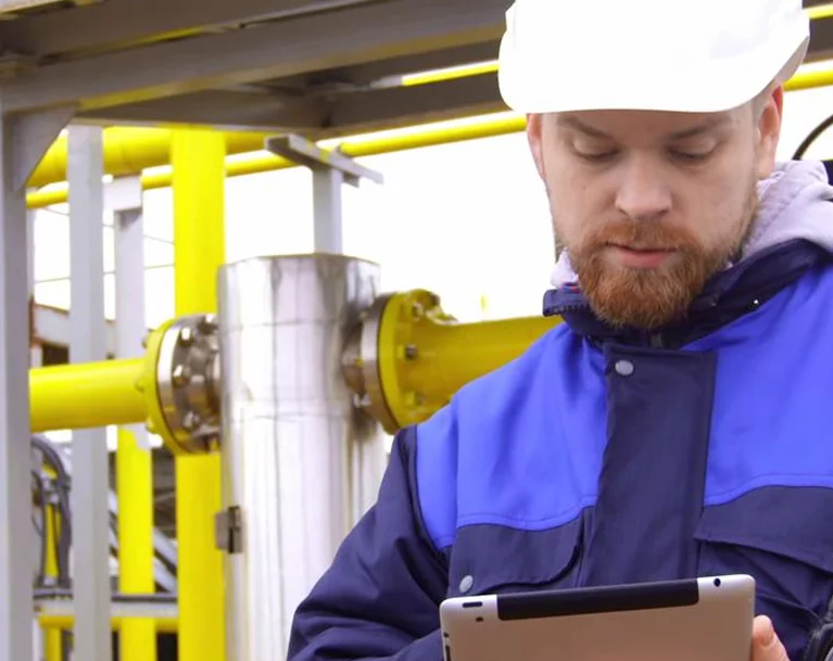 a man in a white helmet using a tablet

