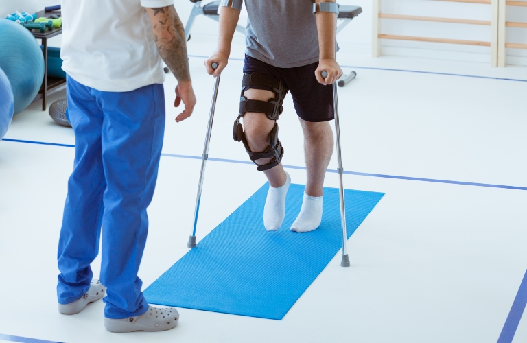 Man on crutches learning to walk in the clinic