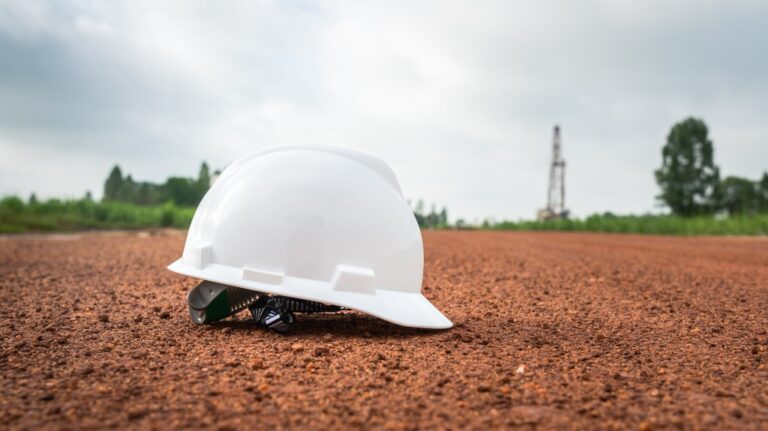 white safety helmet is placed on terrain ground