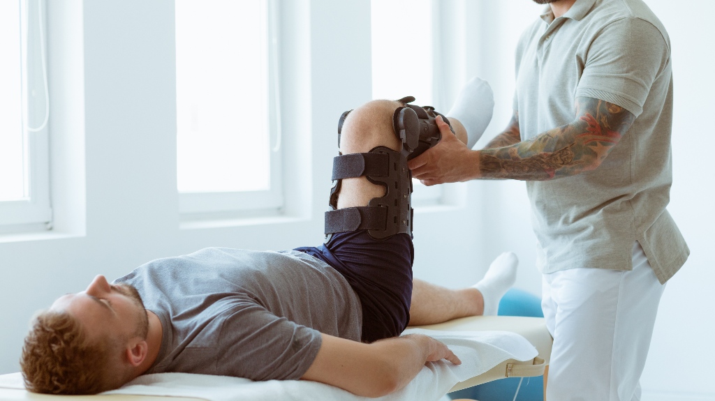 physiotherapist exercises in a bright medical office with his injured patient