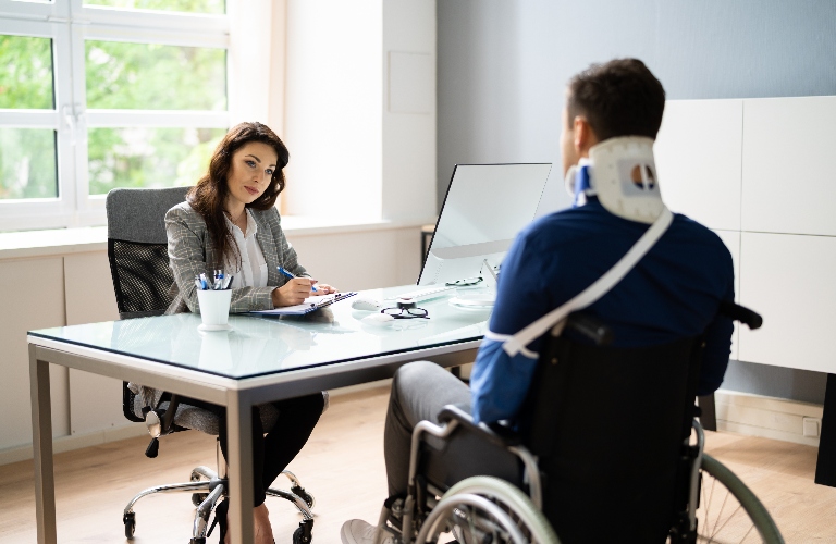 Injured man in wheelchair is consulting with lawyer